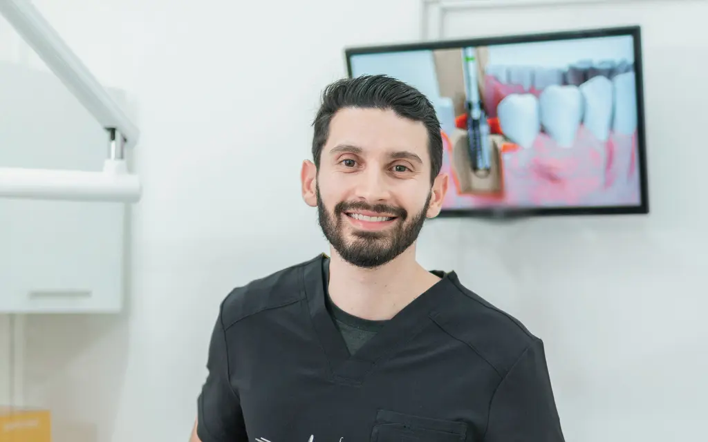 A smiling dentist in scrubs